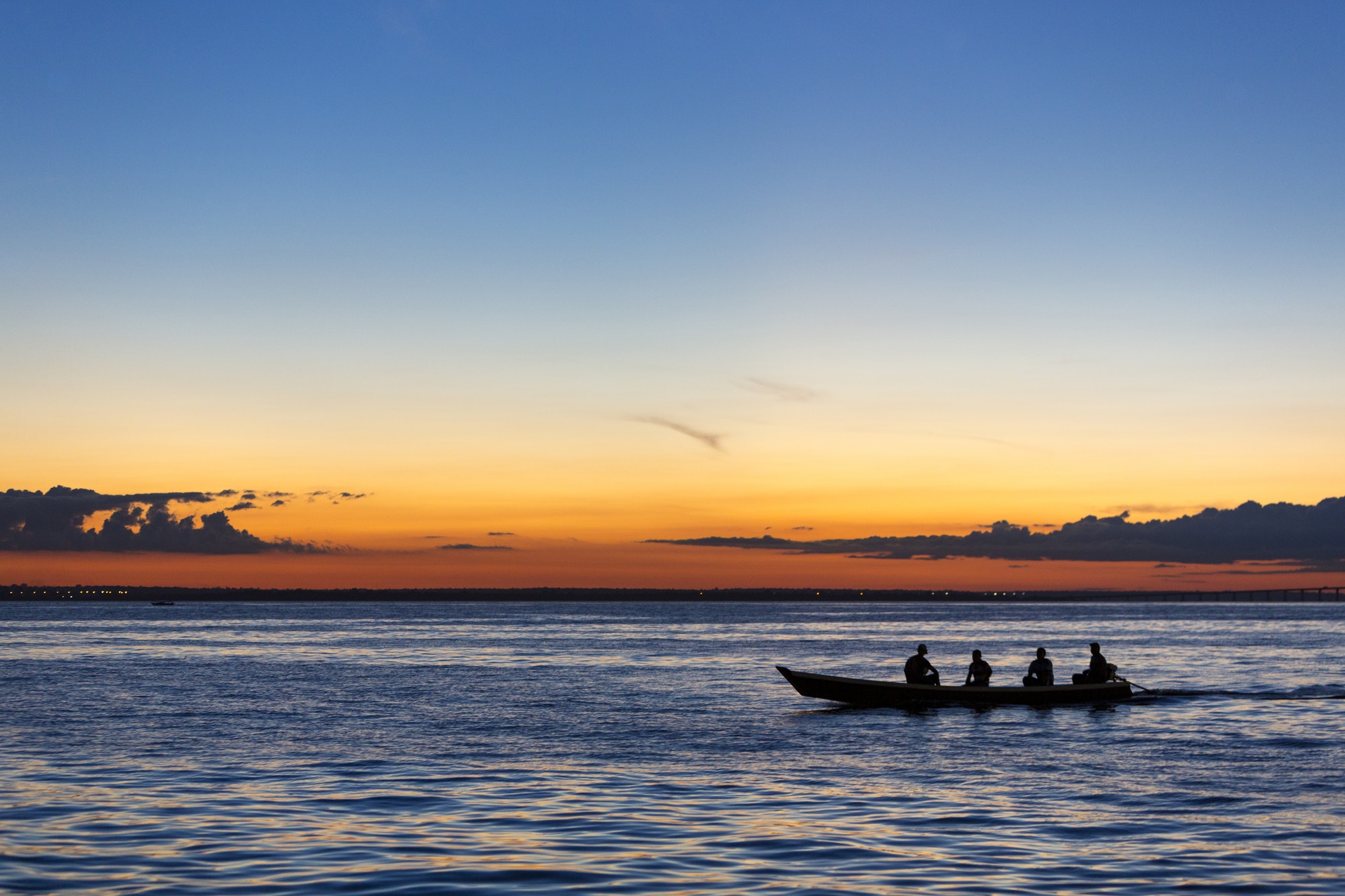 sunset and silhouettes on boat cruising the amazon river brazil