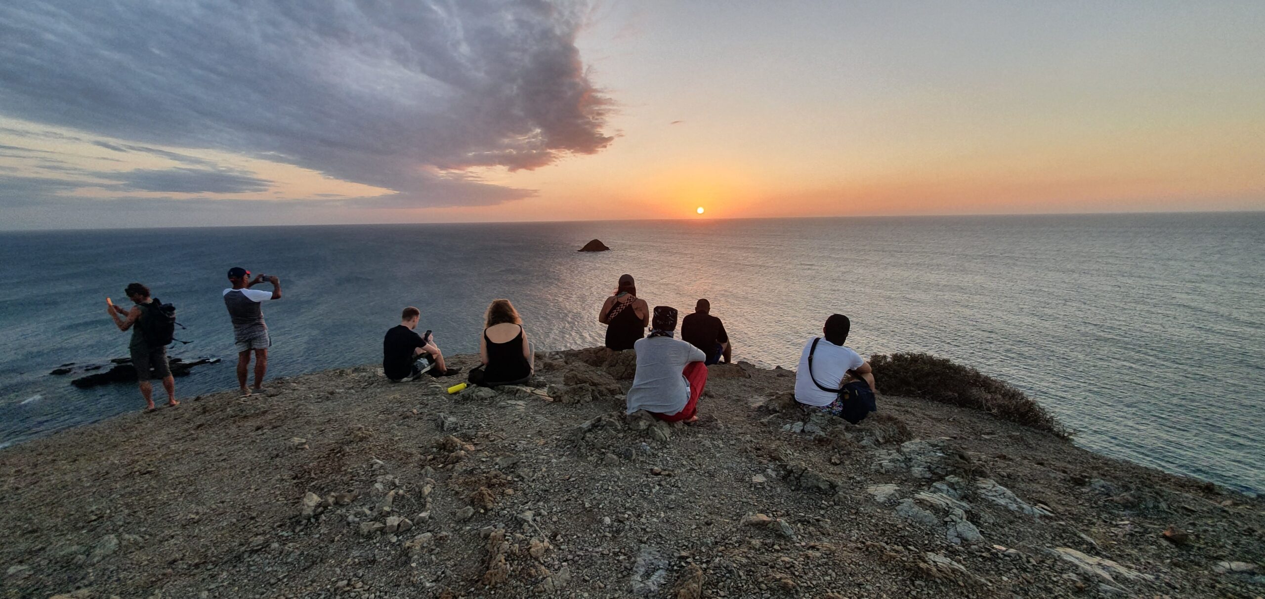 Turistas observando el atardecer frente al mar Caribe en La Guajira
