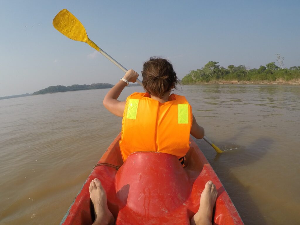 Turista mujer haciendo kayak en el río madre de Dios en el Amazonas de Perú